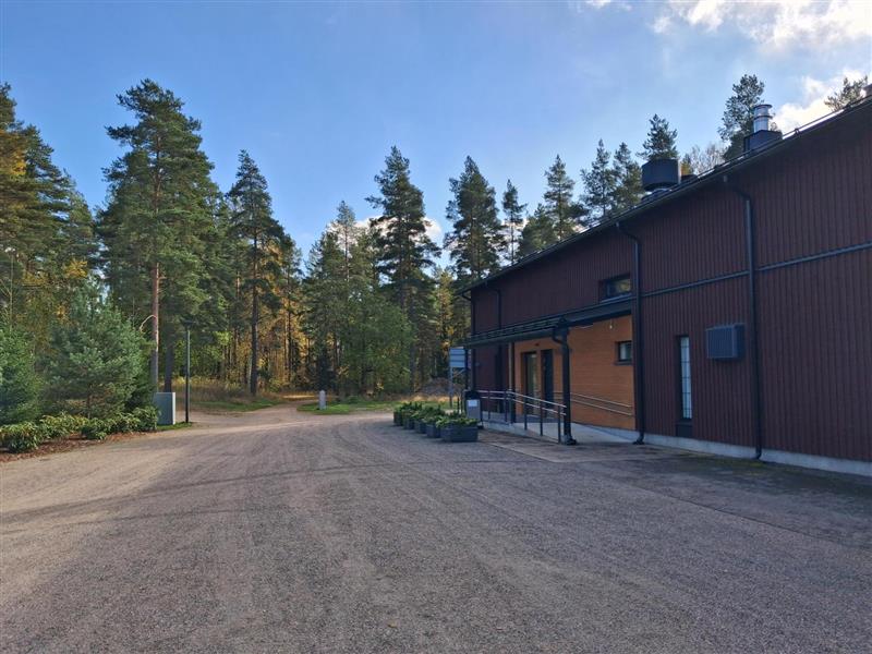 Matala ruskea rakennus metsän reunassa