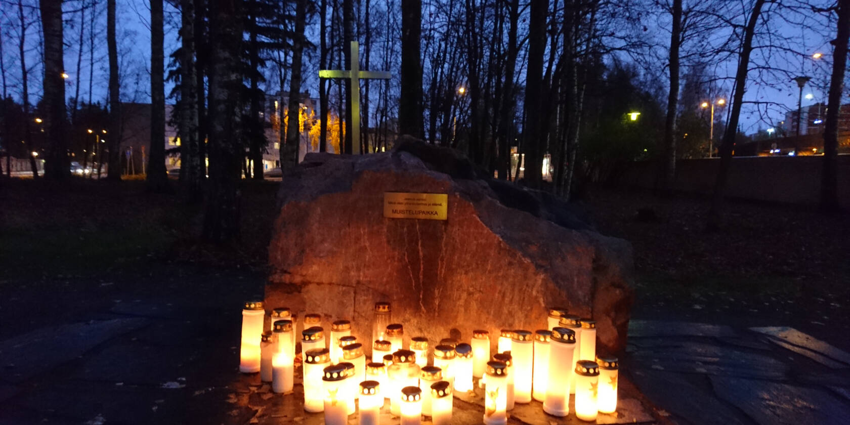 Muistelupaikalla paljon kynttilälyhtyjä, jotka valaisevat illan hämärtyessä.