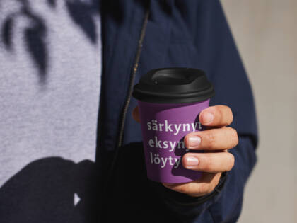 ihminen pitää kädessään kahvikuppia, jossa lukee särkynyt eksynyt löytynyt
