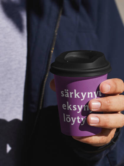 ihminen pitää kädessään kahvikuppia, jossa lukee särkynyt eksynyt löytynyt