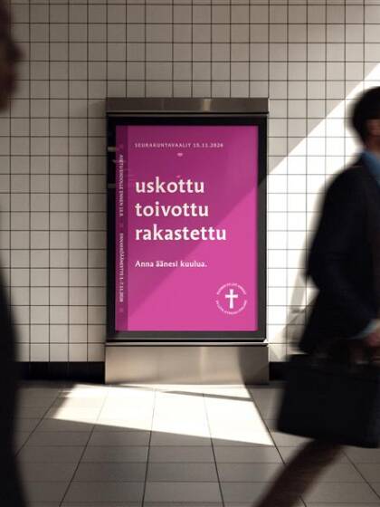 Vaalimainos tunnelin seinällä. Ihmisiä kevelee ohi.
