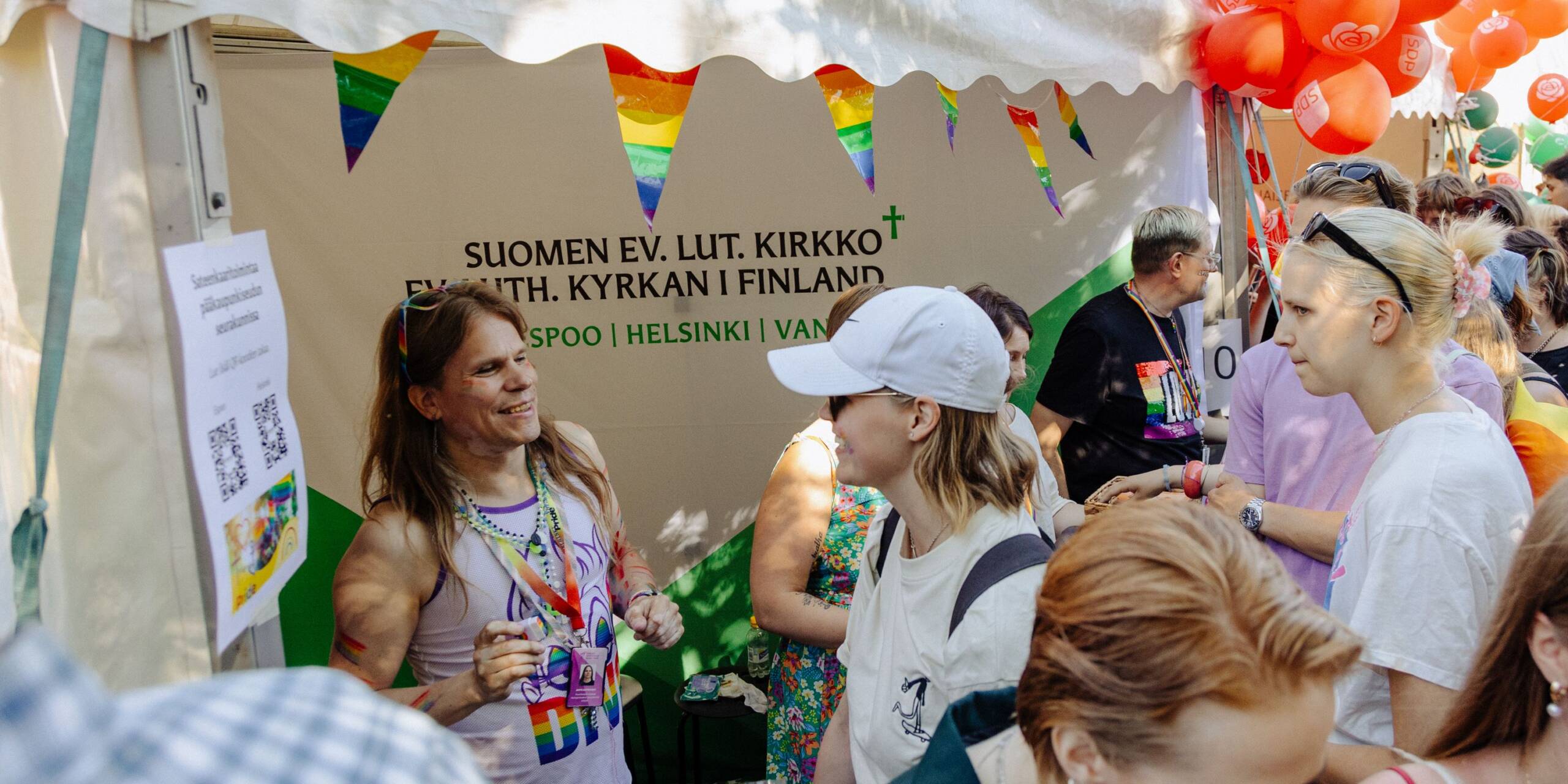 Ihmisiä Pride-tapahtumassa kirkon infopisteellä.