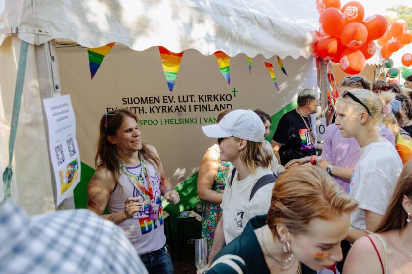 Ihmisiä Pride-tapahtumassa kirkon infopisteellä.