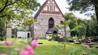 Helsinge kyrka S:t Lars med rosor framför.