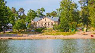 bild på huset på Svartholmen, träd, gräsmatta och lekpark.