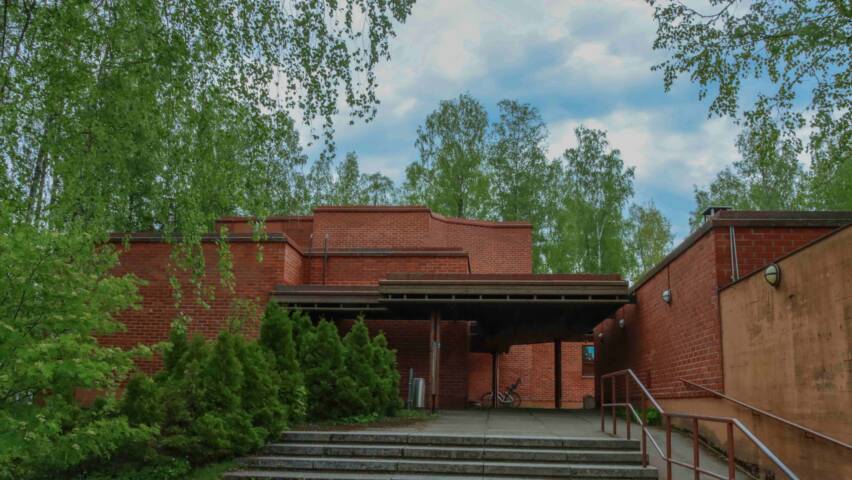 Kivistön kirkon sisääntulo: leveät portaat ja punatiilinen kirkko vasemmalla