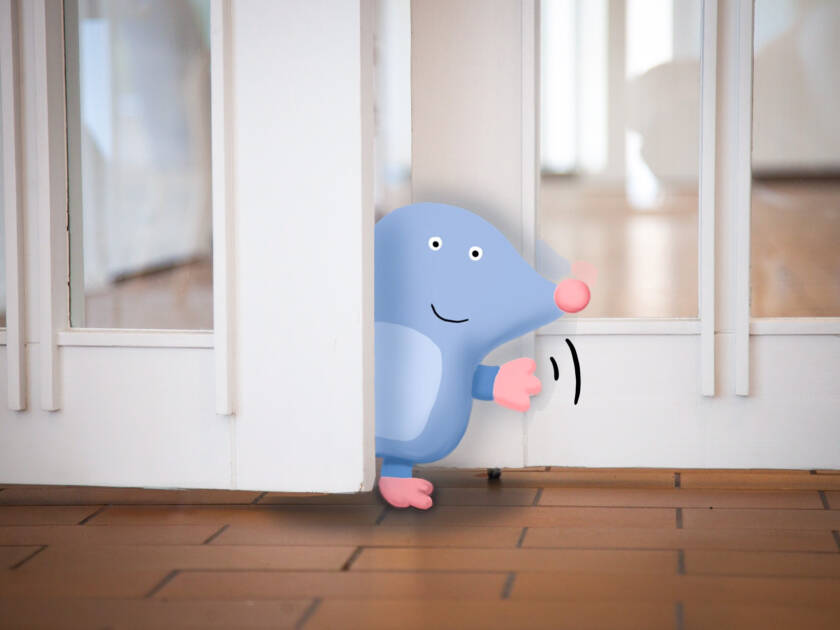 Piirretty Mille-hahmo vilkuttaa valokuvassa Myyrmäen kirkon ovella